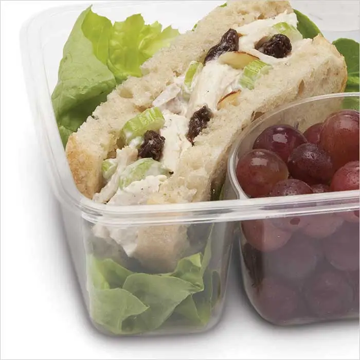 a sandwich and grapes in a container