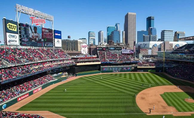 a baseball stadium with a city skyline in the background