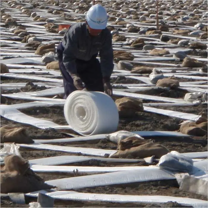 a man rolling a roll of plastic