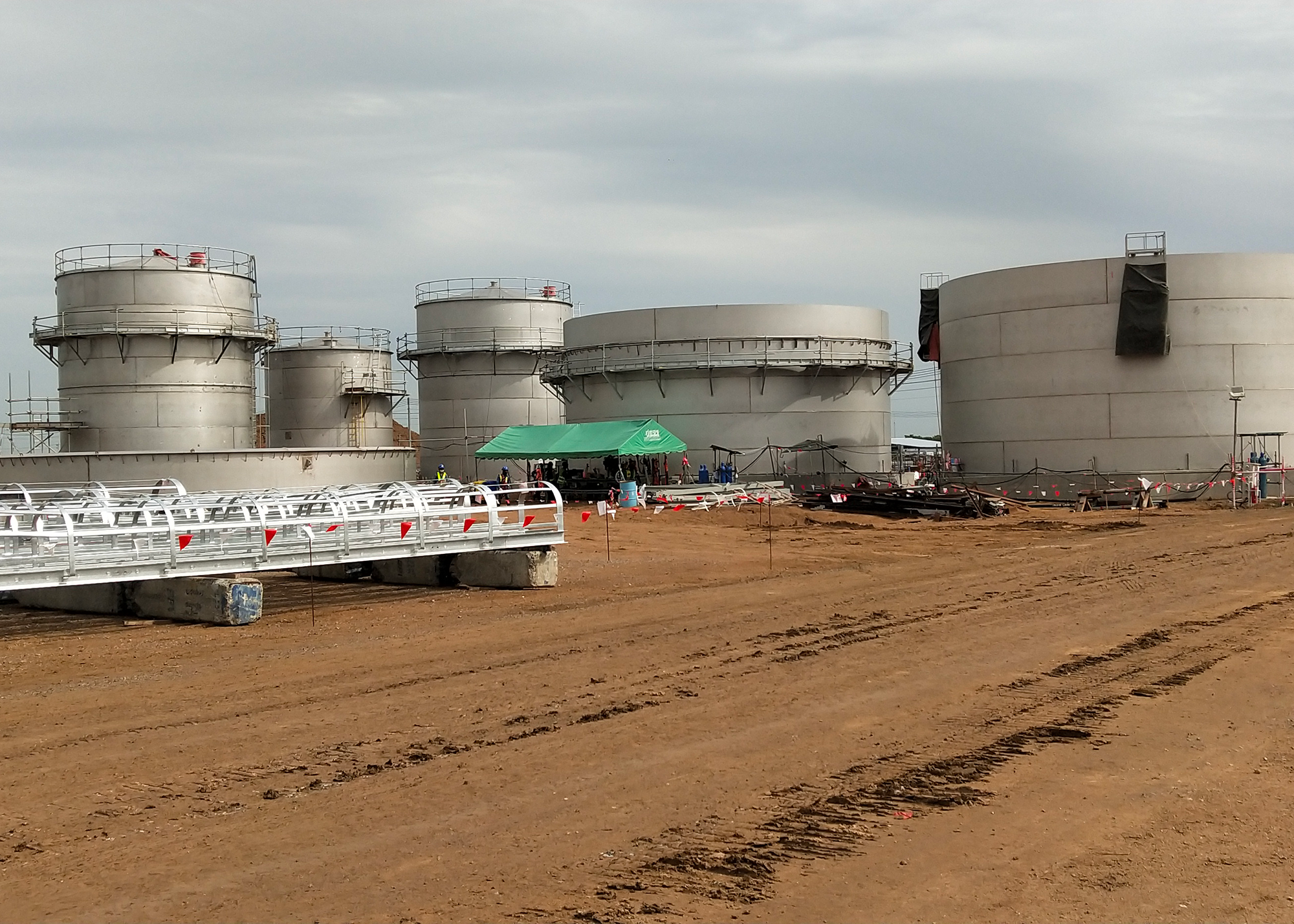 a large metal tanks in a dirt field