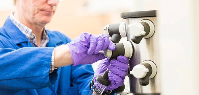 a person wearing gloves and holding a tube