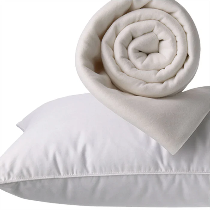a white pillow and a rolled up blanket