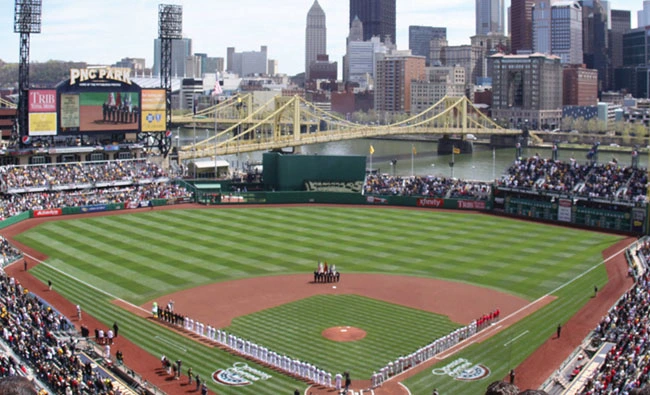 a baseball field with a crowd of people in the background with PNC Park in the background